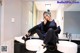 A woman sitting on top of a sink in a bathroom.