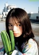 A woman holding a bunch of green onions in her hand.