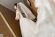 A woman in a wedding dress standing in front of a mirror.