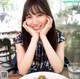 A woman sitting at a table with a plate of food.