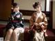 A couple of women in kimonos sitting next to each other.